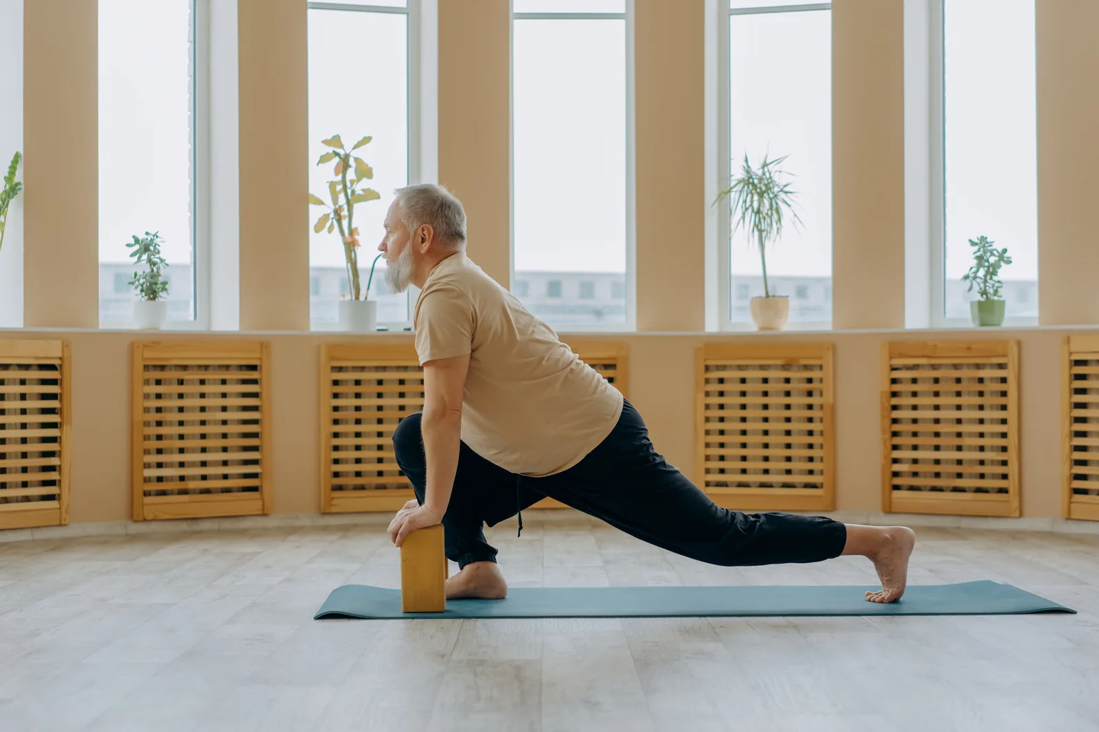 Older man practising gentle yoga and mindful breathing